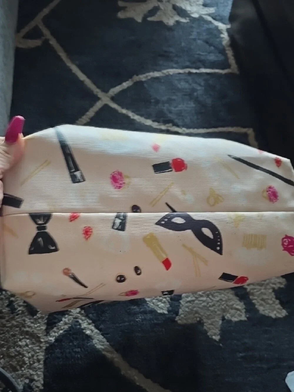 kate spade cream tote with black handles and colorful makeup print